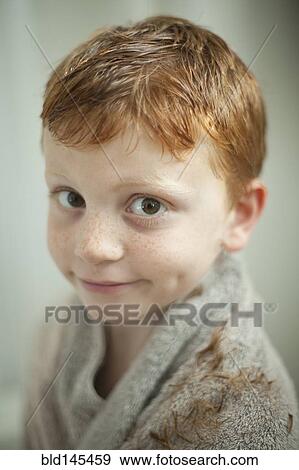 Stock Photo - Caucasian boy wrapped in towel after haircut. Fotosearch