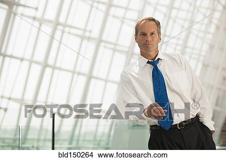 Caucasian businessman leaning on railing View Large Photo Image Picture - Caucasian businessman leaning on railing. Fotosearch