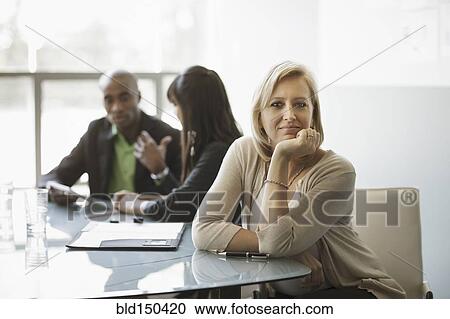 Stock Image - Caucasian businesswoman smiling in meeting. Fotosearch
