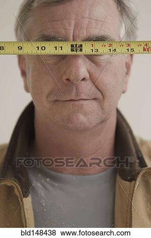Caucasian carpenter covering eyes with measuring tape View Large Photo Image Stock Photo - Caucasian carpenter covering eyes with measuring tape. Fotosearch