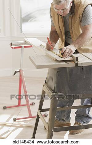 Caucasian carpenter measuring lumber View Large Photo Image Picture - Caucasian carpenter measuring lumber. Fotosearch