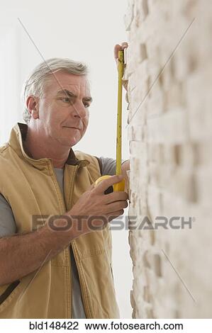 Caucasian carpenter measuring wall View Large Photo Image Stock Image - Caucasian carpenter measuring wall. Fotosearch