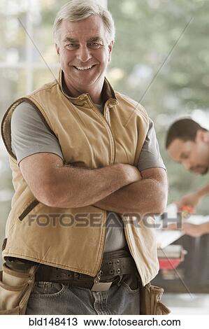 Caucasian carpenter standing with arms crossed View Large Photo Image Stock Image - Caucasian carpenter standing with arms crossed. Fotosearch