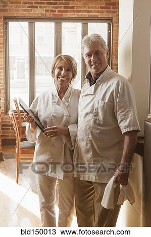 Stock Image - Caucasian chefs standing in restaurant. Fotosearch