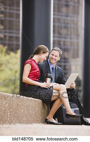 Caucasian co-workers talking outdoors View Large Photo Image Stock Photography - Caucasian co-workers talking outdoors. Fotosearch