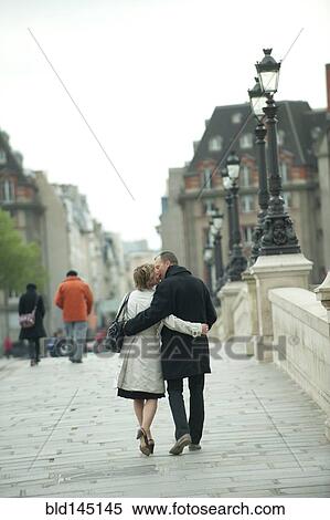 Caucasian couple kissing and walking on bridge View Large Photo Image Stock Photography - Caucasian couple kissing and walking on bridge. Fotosearch