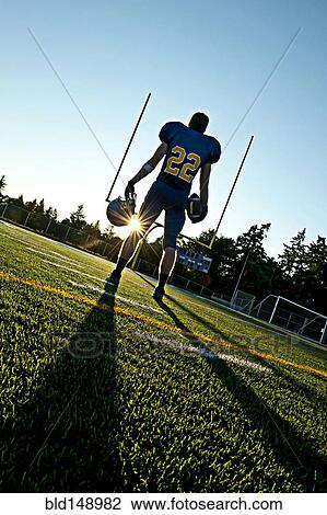 Caucasian football player holding ball View Large Photo Image Stock Image - Caucasian football player holding ball. Fotosearch