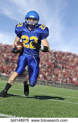 Stock Photograph - Caucasian football player running with ball. Fotosearch