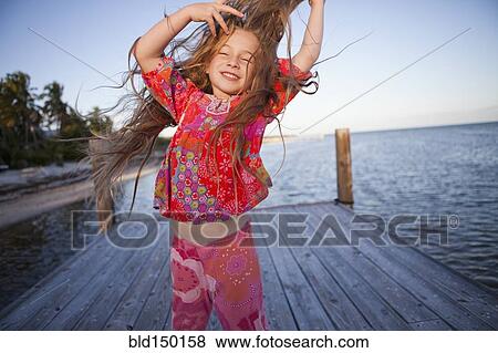 Caucasian girl dancing on pier View Large Photo Image Stock Photo - Caucasian girl dancing on pier. Fotosearch