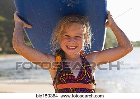 Picture - Caucasian girl holding paddle board. Fotosearch
