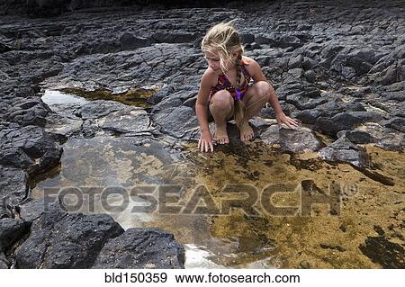 Stock Photo - Caucasian girl playing near tide pools. Fotosearch