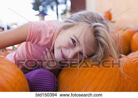 Picture - Caucasian girl sitting with pumpkins. Fotosearch