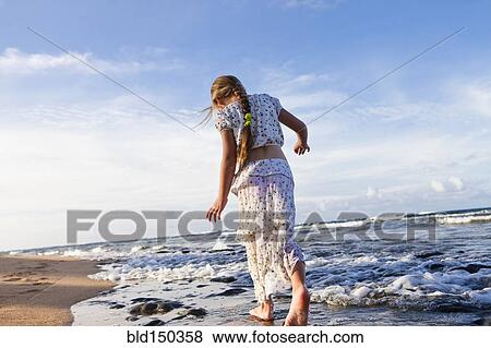 Stock Photo - Caucasian girl walking on beach. Fotosearch