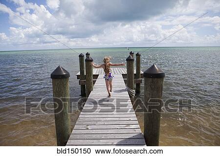 Caucasian girl walking on pier View Large Photo Image Stock Image - Caucasian girl walking on pier. Fotosearch