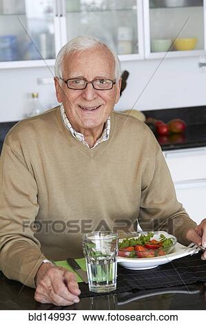 Caucasian man eating healthy salad View Large Photo Image Stock Photo - Caucasian man eating healthy salad. Fotosearch