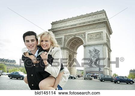 Caucasian man giving girlfriend piggyback ride near Arc de Triomphe View Large Photo Image Picture - Caucasian man giving girlfriend piggyback ride near Arc de Triomphe. Fotosearch