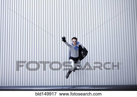 Stock Photo - Caucasian man jumping in superhero costume. Fotosearch