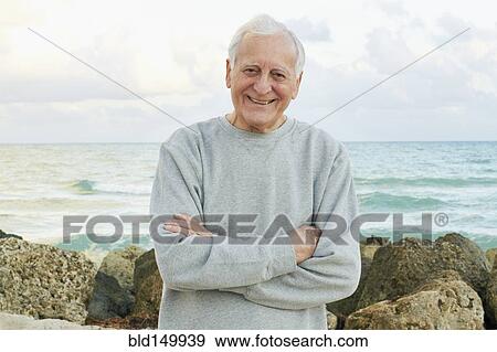 Stock Photo - Caucasian man standing near ocean. Fotosearch