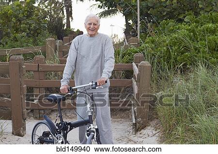Caucasian man standing with bicycle View Large Photo Image Stock Image - Caucasian man standing with bicycle. Fotosearch