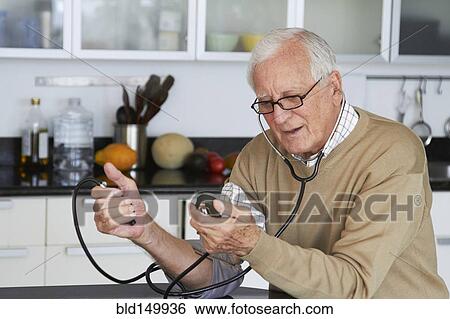 Caucasian man taking his own blood pressure View Large Photo Image Stock Photograph - Caucasian man taking his own blood pressure. Fotosearch
