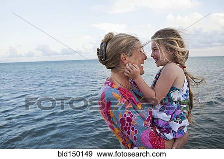 Stock Photo - Caucasian mother and daughter enjoying the beach. Fotosearch