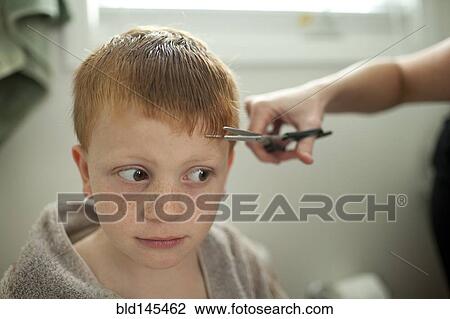Stock Image - Caucasian mother giving son haircut. Fotosearch
