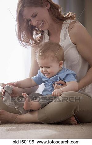 Stock Photography - Caucasian mother holding son on lap. Fotosearch