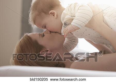 Stock Photography - Caucasian mother kissing son. Fotosearch