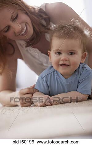 Caucasian mother laying on floor playing with son View Large Photo Image Stock Photograph - Caucasian mother laying on floor playing with son. Fotosearch