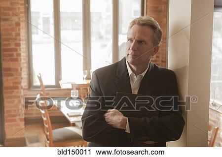Stock Image - Caucasian owner standing in restaurant. Fotosearch