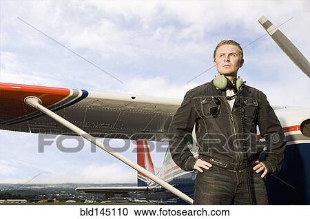 Caucasian pilot standing near small airplane View Large Photo Image Stock Image - Caucasian pilot standing near small airplane. Fotosearch
