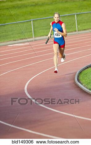 Caucasian runner holding baton running on track View Large Photo Image Stock Photograph - Caucasian runner holding baton running on track. Fotosearch