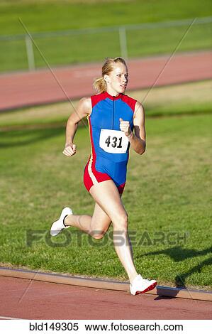 Stock Photography - Caucasian runner running on track. Fotosearch