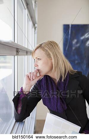 Caucasian woman looking out window View Large Photo Image Picture - Caucasian woman looking out window. Fotosearch