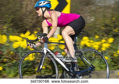 Stock Photograph - Caucasian woman riding bicycle. Fotosearch