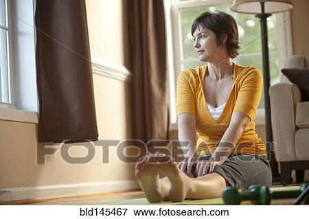 Caucasian woman sitting on exercise mat View Large Photo Image Stock Photo - Caucasian woman sitting on exercise mat. Fotosearch