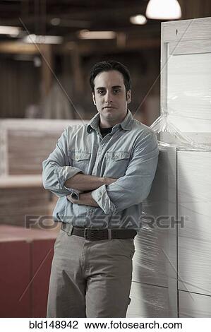 Caucasian worker standing in warehouse View Large Photo Image Stock Image - Caucasian worker standing in warehouse. Fotosearch