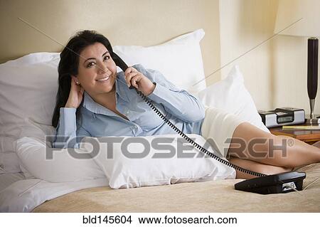 Chilean businesswoman laying on bed talking on telephone View Large Photo Image Picture - Chilean businesswoman laying on bed talking on telephone. Fotosearch
