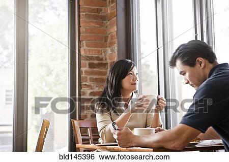 Stock Photograph - Chinese couple drinking coffee in cafe. Fotosearch