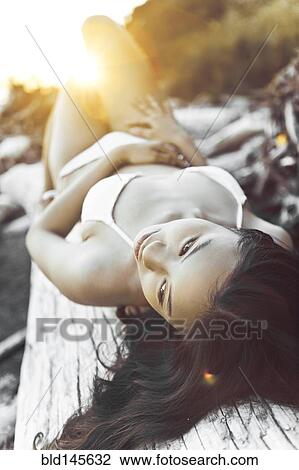 Chinese woman in bikini laying on log View Large Photo Image Stock Image - Chinese woman in bikini laying on log. Fotosearch