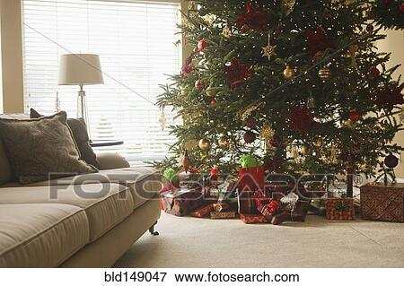 Stock Photo - Christmas tree and gifts in living room. Fotosearch
