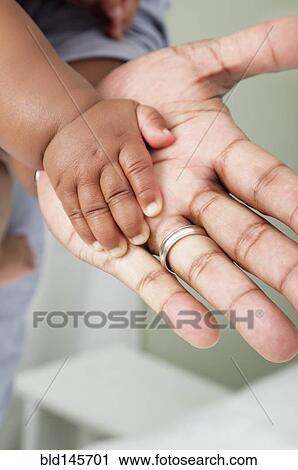 Close up of African American father and baby son's hands View Large Photo Image Stock Image - Close up of African American father and baby son's hands. Fotosearch