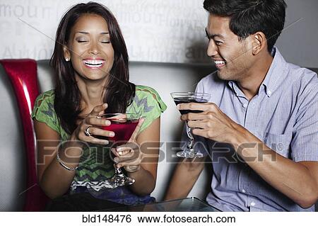 Couple drinking cocktails in nightclub View Large Photo Image Stock Photograph - Couple drinking cocktails in nightclub. Fotosearch