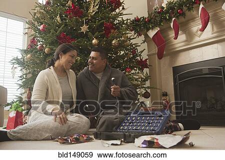 Stock Photo - Couple opening gifts on Christmas morning. Fotosearch