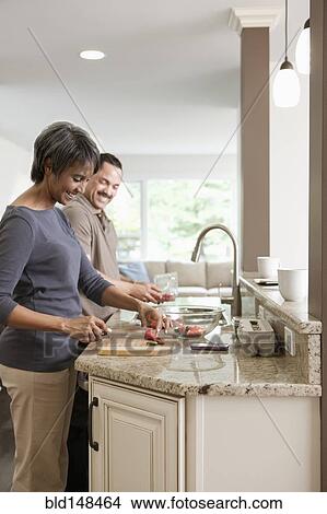 Couple preparing meal together in kitchen View Large Photo Image Picture - Couple preparing meal together in kitchen. Fotosearch