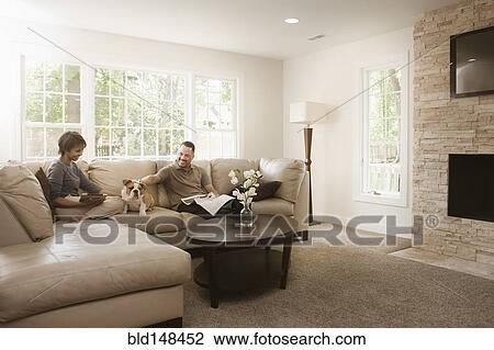 Couple sitting on sofa with English bulldog View Large Photo Image Stock Image - Couple sitting on sofa with English bulldog. Fotosearch