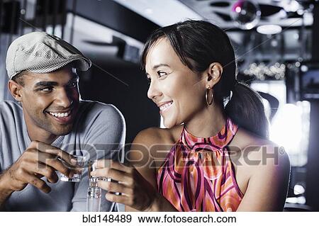 Couple toasting in nightclub View Large Photo Image Stock Photo - Couple toasting in nightclub. Fotosearch
