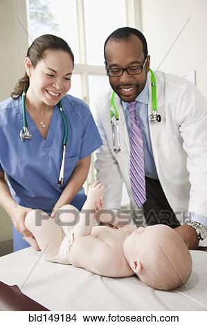 Doctor and nurse examining baby in doctor's office View Large Photo Image Picture - Doctor and nurse examining baby in doctor's office. Fotosearch