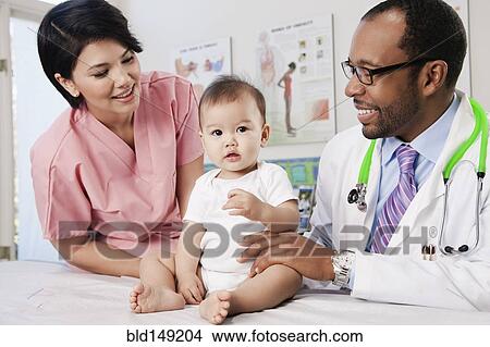 Doctor and nurse examining baby in doctor's office View Large Photo Image Picture - Doctor and nurse examining baby in doctor's office. Fotosearch