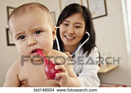 Picture - Doctor examining baby boy. Fotosearch